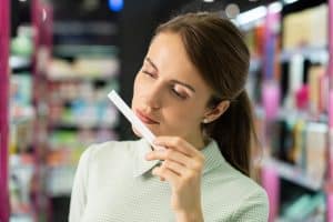 brunette woman smelling perfume