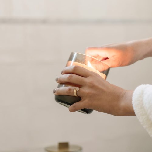 woman's hand lighting a candle in winter