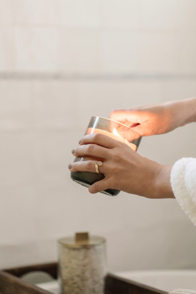 woman's hand lighting a candle in winter