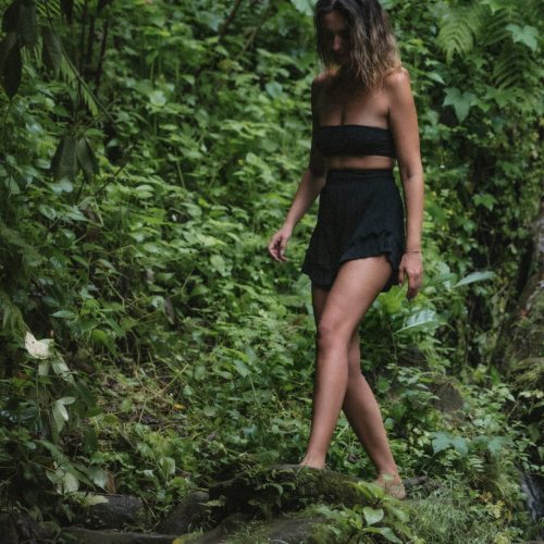 Woman wearing black walking in a rainforest