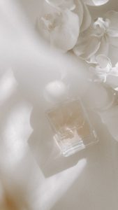 Perfume with white lid and white flowers