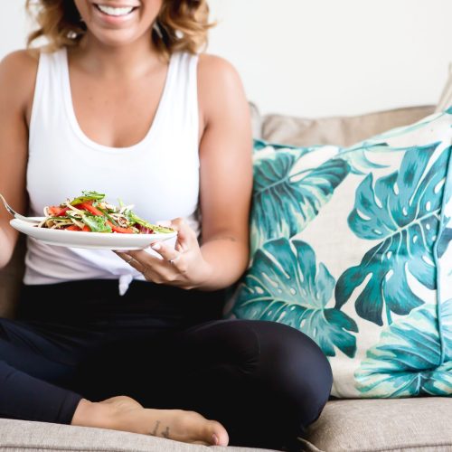 Beautiful woman in workout clothing eating a salad